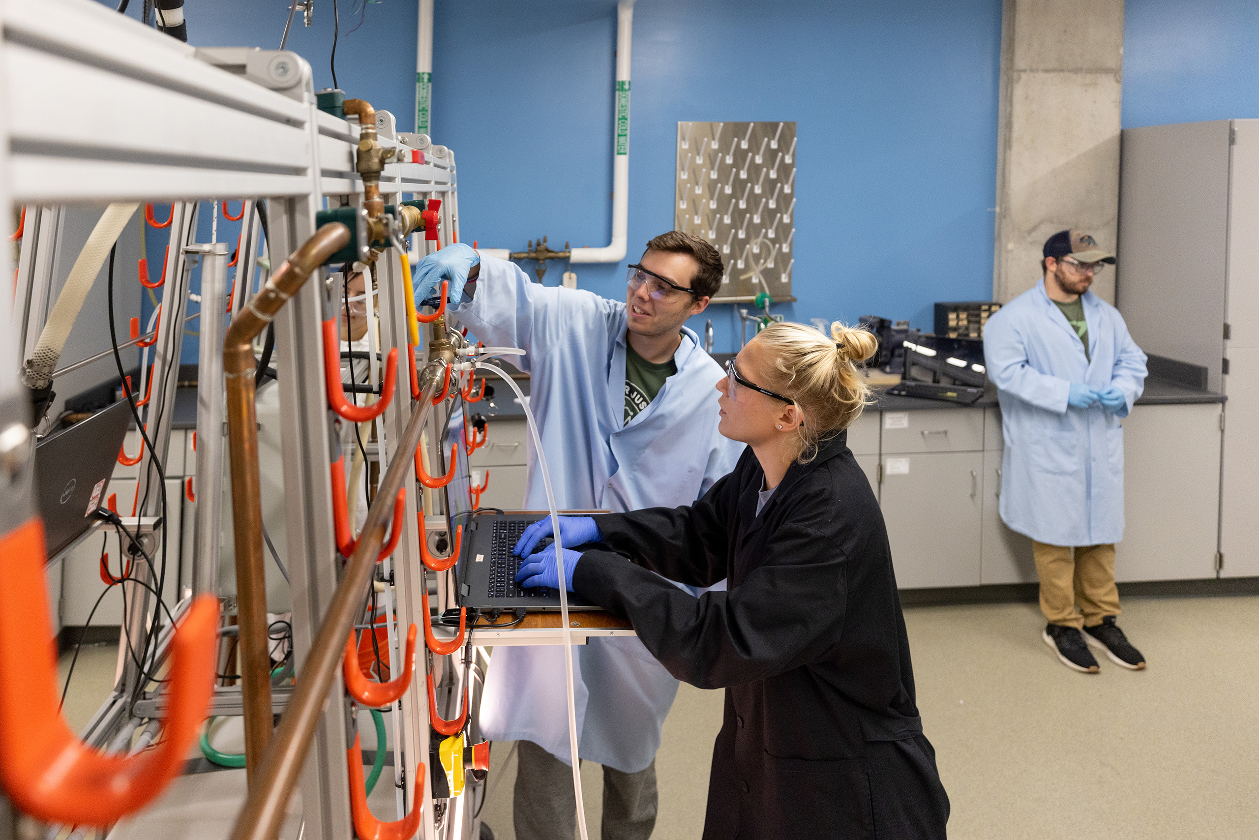 Students working with a piece of equipment in a lab