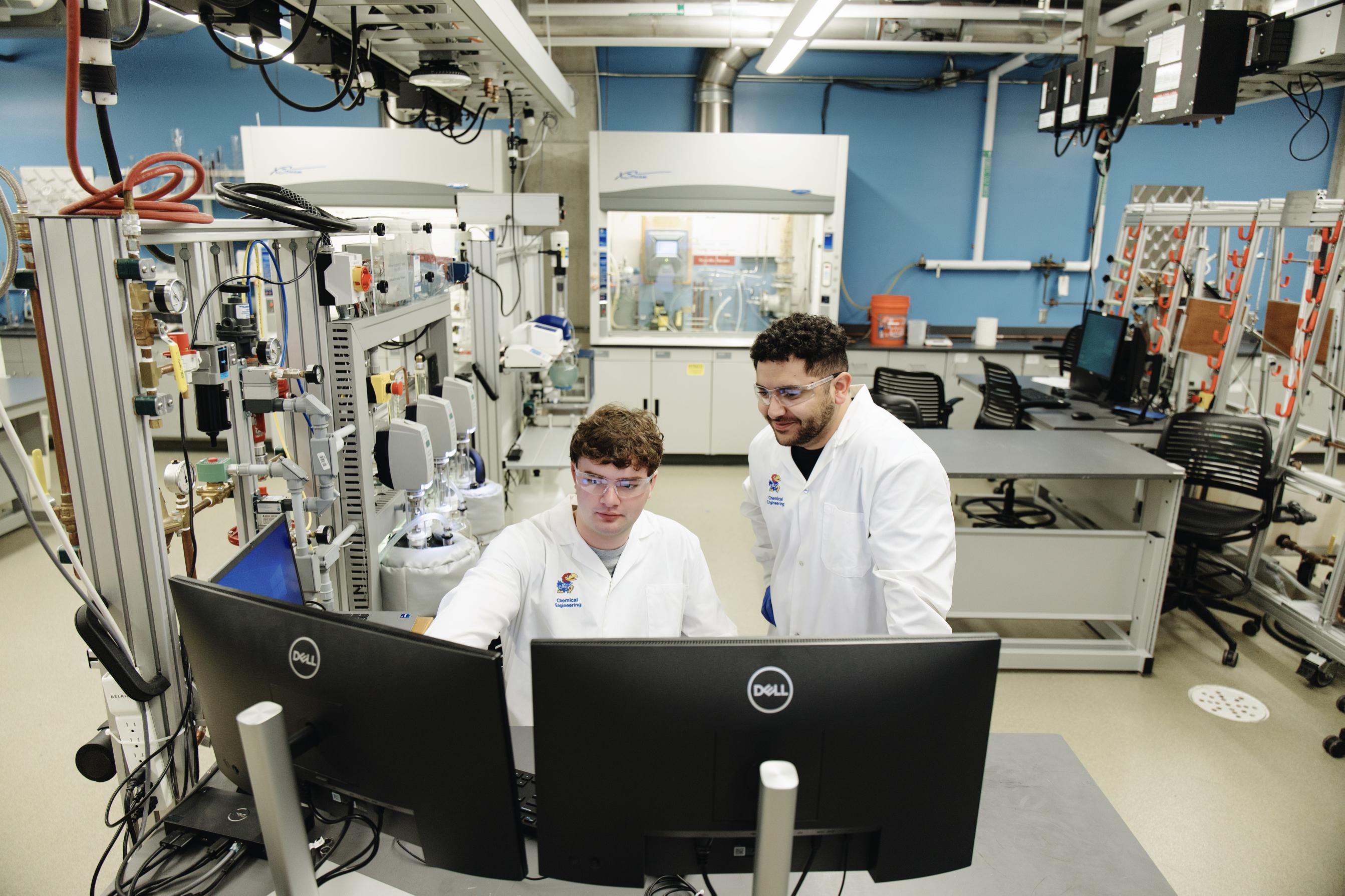 Two students looking at a monitor in the lab