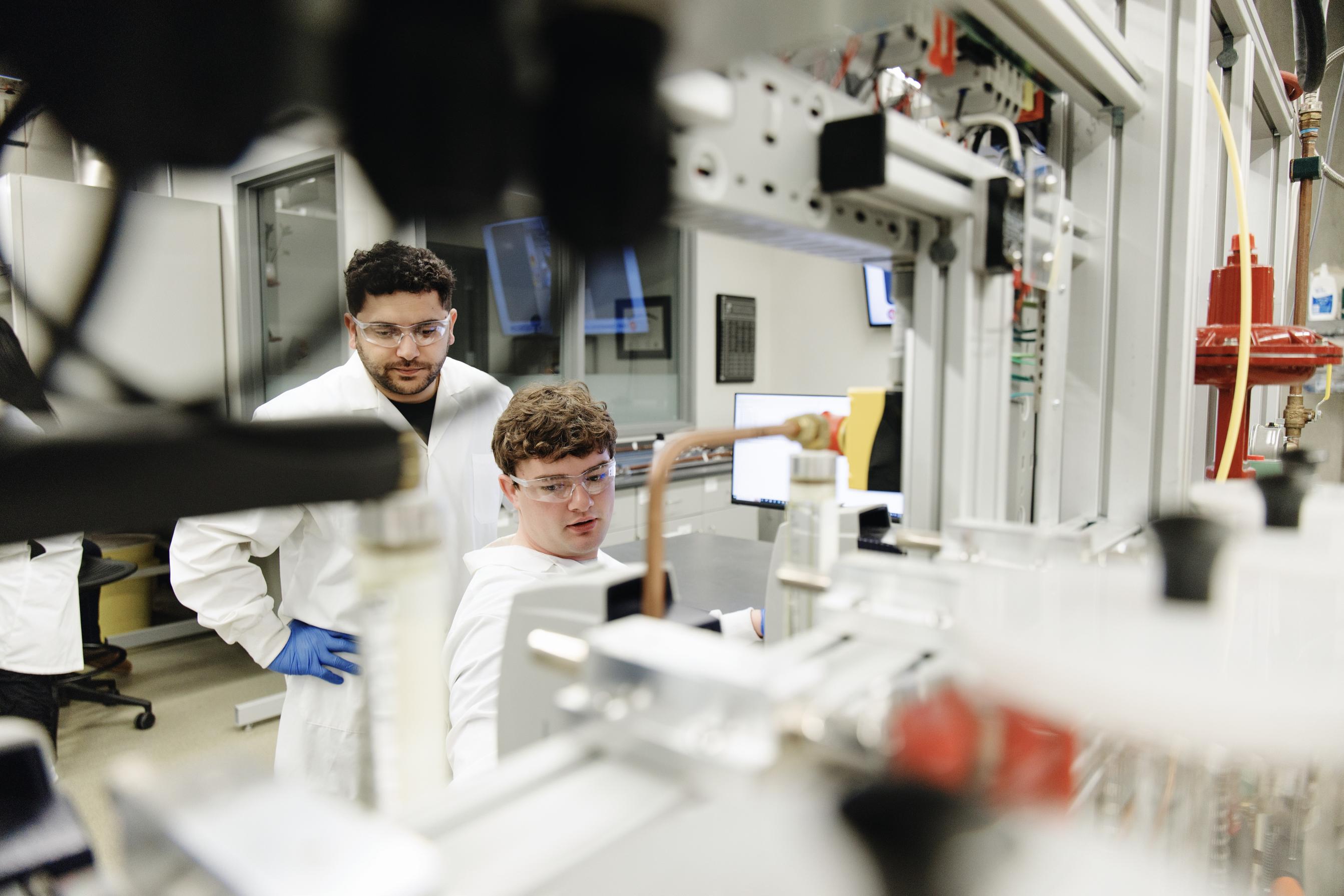 Two students looking at an item in the lab