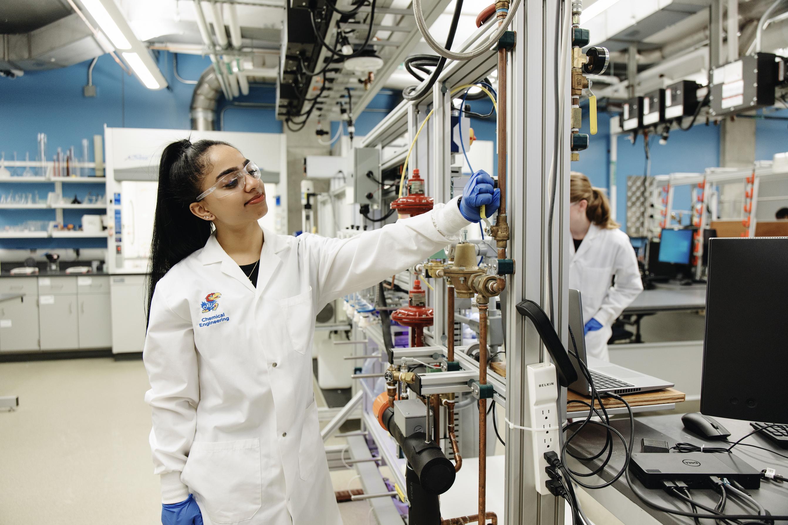 A student turning a valve